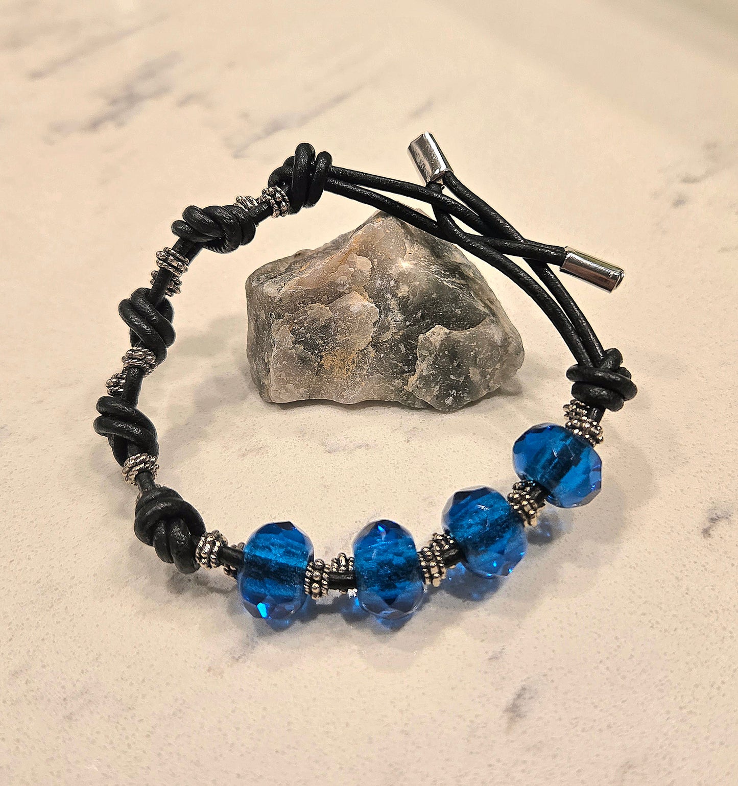 Knotted black leather bracelet with blue czech glass beads