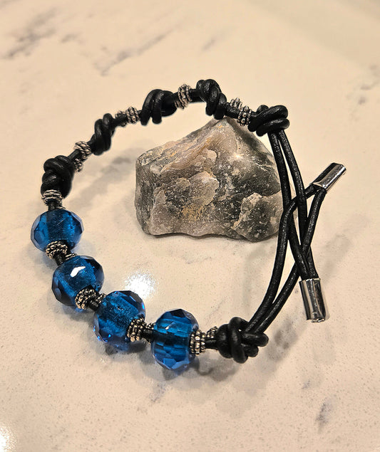 Knotted black leather bracelet with blue czech glass beads